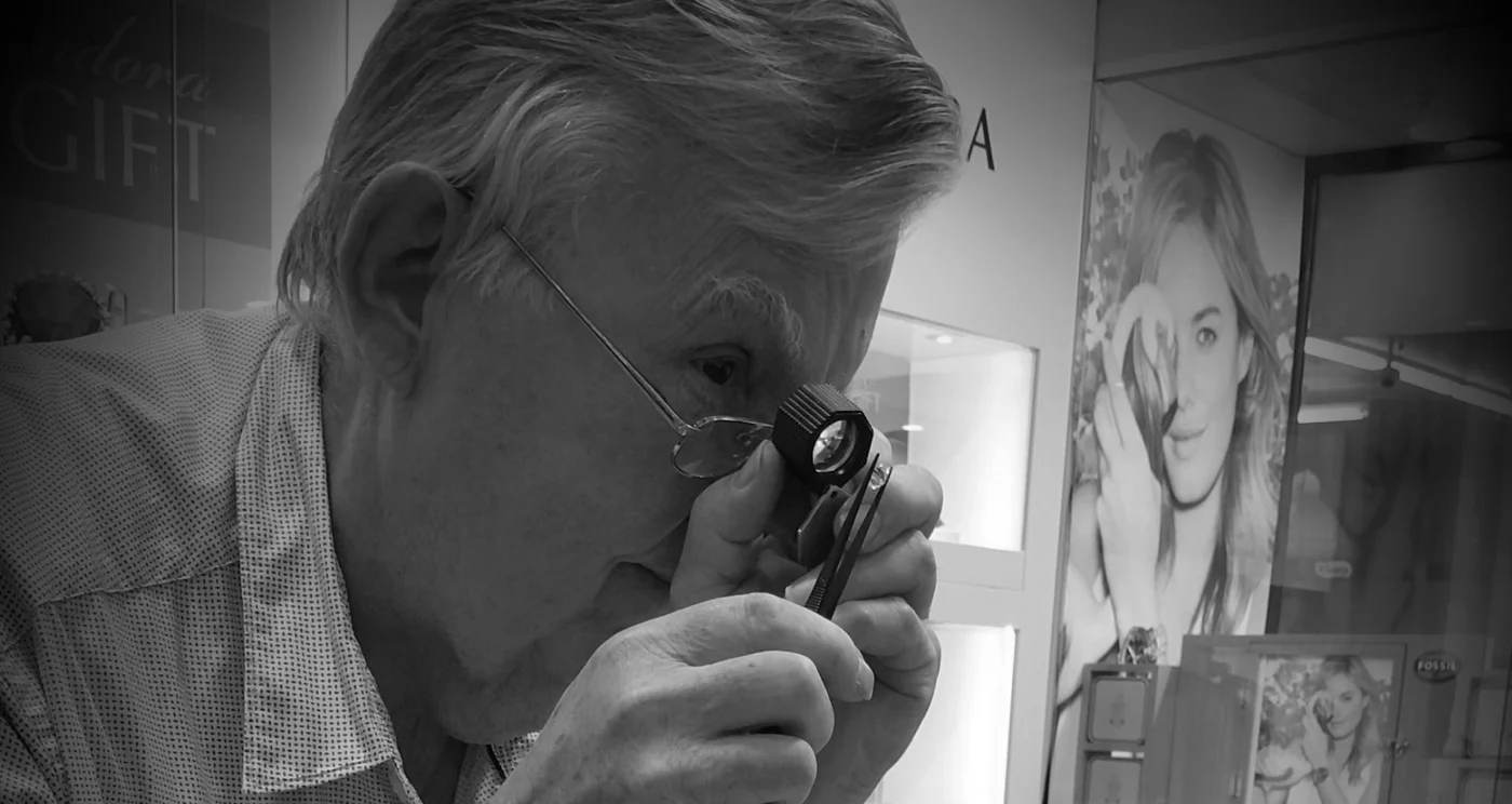 Charles Priest examining a piece through a jeweller’s loupe